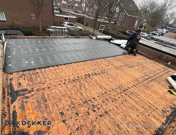 Dakdekker legt onderlaag op plat dak met houten constructie in Prinsenbeek