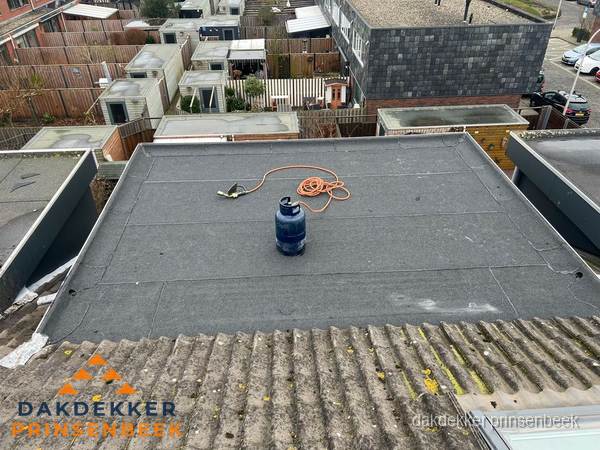 Plat dak met bitumen dakbedekking en brander in Prinsenbeek