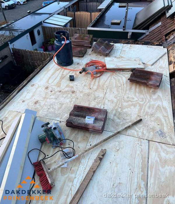 Dakreparatie werkzaamheden op plat dak met gereedschap in Prinsenbeek