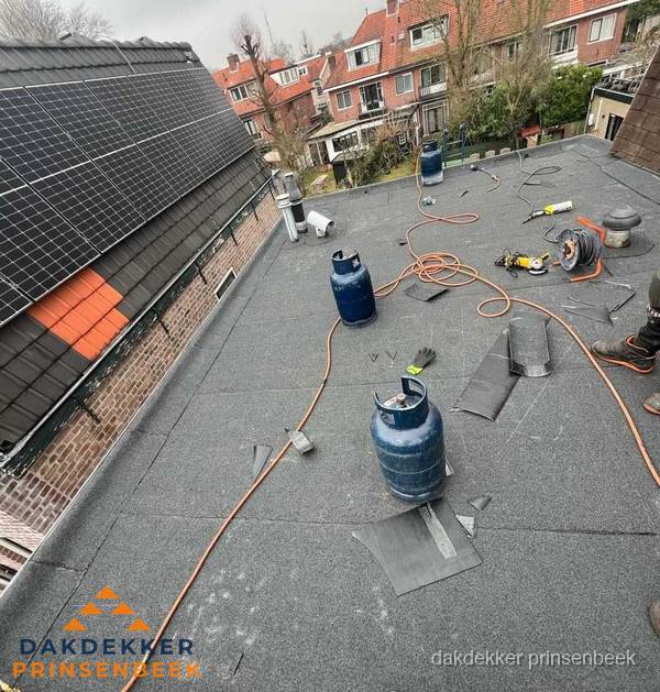 Daklekkage repareren met brandgereedschap op plat dak in Prinsenbeek