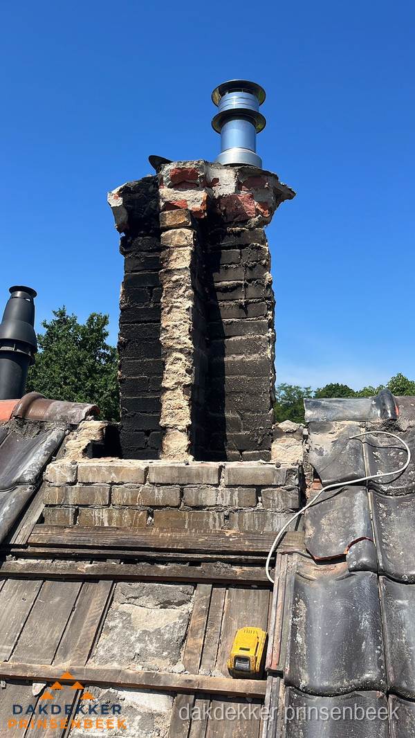 Beschadigde schoorsteen met nieuwe rookgasafvoer op oud dak in Prinsenbeek