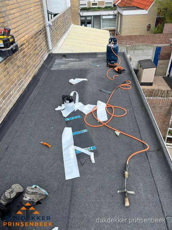 Dakdekkers bezig met bitumen dakbedekking in Prinsenbeek