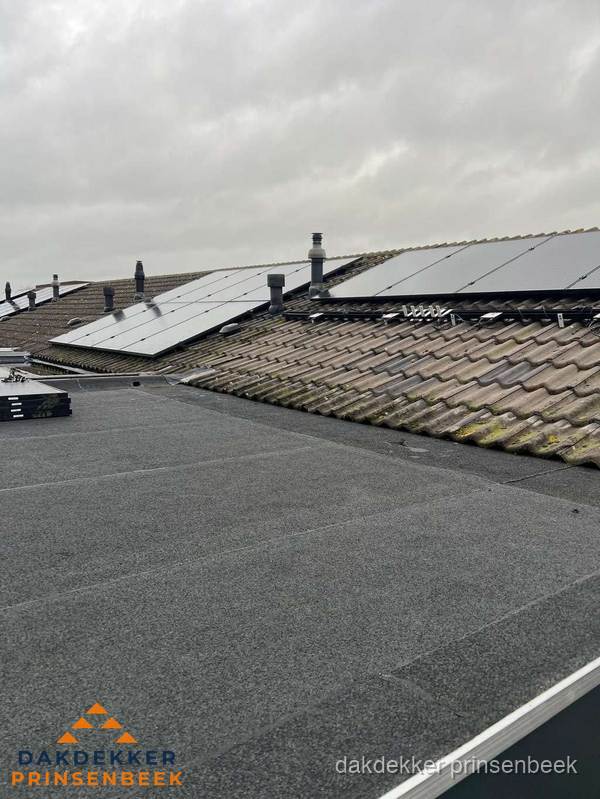 Bitumen dakbedekking op plat dak met aansluitend pannendak en zonnepanelen in Prinsenbeek