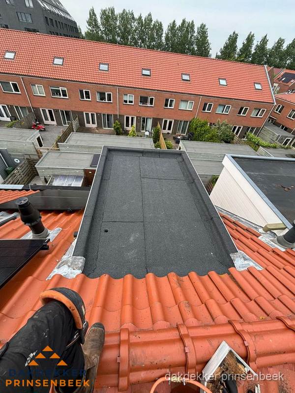 Bitumen dak reparatie op plat dak tussen dakpannen in Prinsenbeek