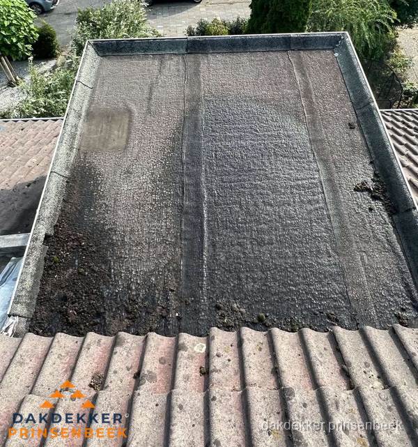 Verouderd plat dak met bitumen en slijtage voor lekkage inspectie in Prinsenbeek