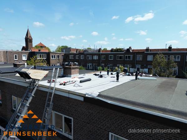 Dakdekkers aan het werk op plat dak in Prinsenbeek