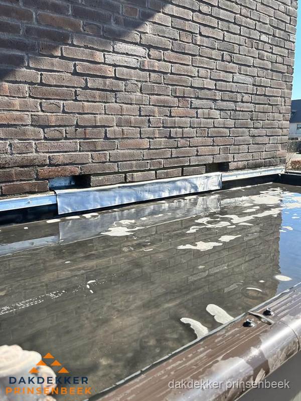Stilstaand water op plat dak door slechte afwatering in Prinsenbeek Stilstaand water op plat dak door slechte afwatering in Prinsenbeek